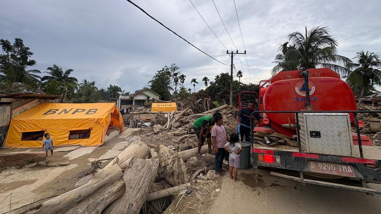 Petugas gabungan saat menyalurkan bantuan air bersih menggunakan mobil tangki kepada warga terdampak bencana di Kabupaten Aceh Tamiang.