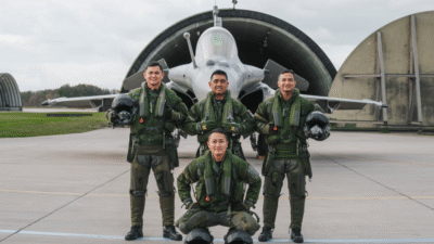 Empat pilot Indonesia mengenakan seragam penerbang lengkap dan memegang helm berpose gagah di depan pesawat tempur Rafale di dalam hanggar. (Dok. Ist)