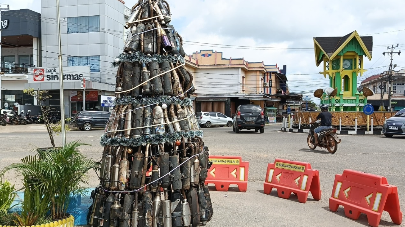 Pohon Natal unik setinggi tiga meter yang tersusun dari ratusan knalpot brong hasil sitaan Satlantas Polres Ketapang, terpasang di Pos Ale-Ale, Rabu (24/12/2025). (Dok. HO/Faktakalbar.id)