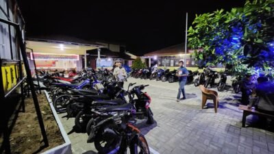 Jajaran personel Polsek Delta Pawan saat mengamankan puluhan sepeda motor yang terlibat balap liar dan menggunakan knalpot brong di Mapolsek Delta Pawan, Minggu (14/12/2025).