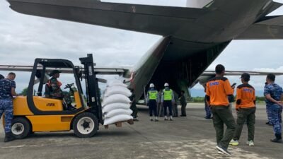 Petugas gabungan saat memuat karung beras bantuan Perum Bulog ke dalam pesawat Hercules TNI AU di Lanud Sultan Iskandar Muda untuk didistribusikan ke Bener Meriah, Jumat (12/12).
