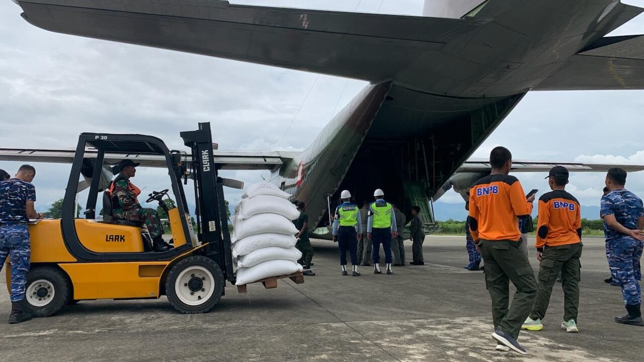 Petugas gabungan saat memuat karung beras bantuan Perum Bulog ke dalam pesawat Hercules TNI AU di Lanud Sultan Iskandar Muda untuk didistribusikan ke Bener Meriah, Jumat (12/12).
