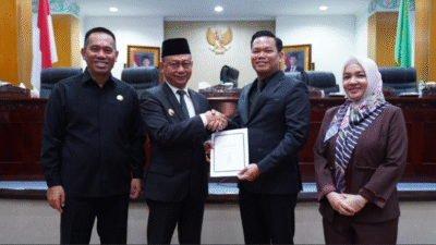 Wali Kota Pontianak Edi Rusdi Kamtono bersalaman dengan pimpinan DPRD sambil memegang map dokumen putih di dalam ruang sidang paripurna. (Dok. HO/Faktakalbar.id)