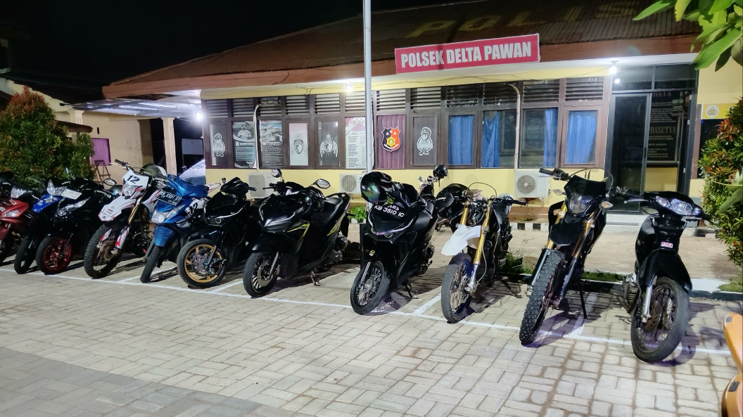 Puluhan sepeda motor berbagai jenis terparkir rapi di depan kantor Polsek Delta Pawan pada malam hari hasil razia penertiban lalu lintas. (Dok. HO/Faktakalbar.id)