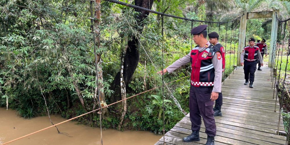 Personel Sat Samapta Polres Bengkayang memantau debit air sungai dan kondisi tebing rawan longsor di Kecamatan Lumar sebagai antisipasi bencana. (Dok. HO/Faktakalbar.id)