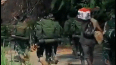 Sejumlah prajurit TNI berseragam loreng berjalan kaki memikul kardus bantuan logistik melewati jalan tanah berlumpur di tengah hutan. (Dok. HO/Faktakalbar.id)