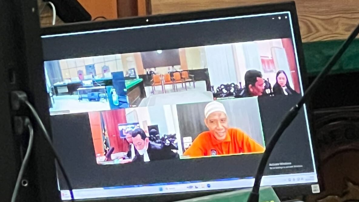 "Terdakwa kasus dugaan pemerasan, Edi Ashari (kanan bawah), mengikuti jalannya sidang perdana secara virtual di Pengadilan Negeri Pontianak, Selasa (02/12/2025). Dalam sidang yang beragendakan pemeriksaan saksi pelapor ini, terdakwa tampak mengenakan rompi tahanan berwarna oranye dan peci putih."