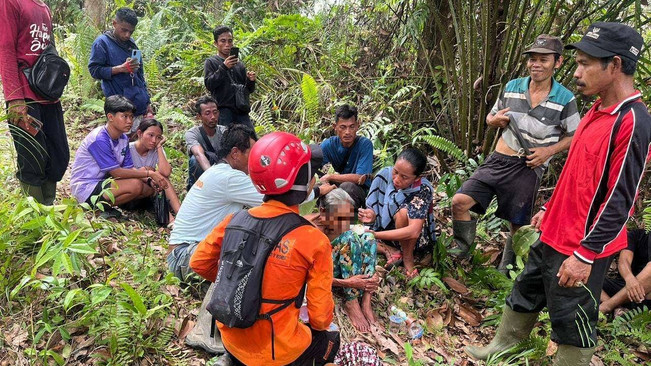 Personel Tim SAR Gabungan saat melakukan proses evakuasi terhadap Nenek Kasitem (71) yang ditemukan selamat di area perkebunan Desa Bancoh, Kabupaten Sintang, Kamis (11/12/2025).