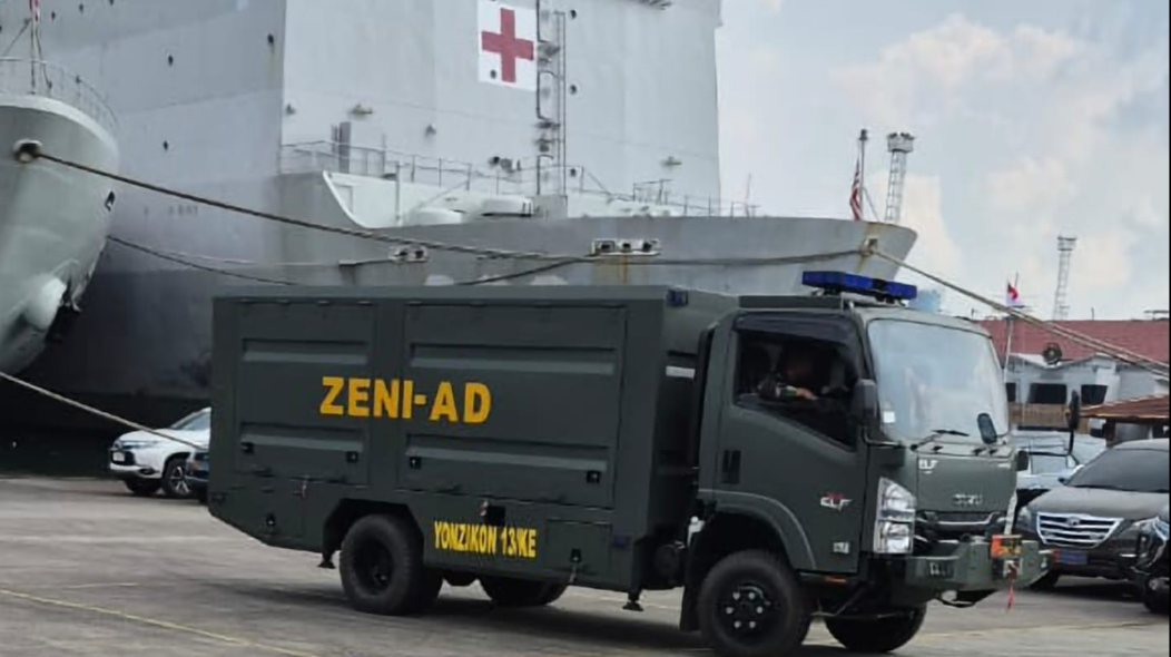 Truk Zeni AD Yonzikon 13 memuat bantuan logistik dan peralatan berat ke kapal TNI AL untuk dikirim ke lokasi bencana di Sumatera. (Dok. Dispen TNI AD)