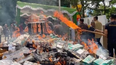 Petugas Kejaksaan Negeri Pontianak saat melakukan pemusnahan ratusan ribu batang rokok ilegal tanpa pita cukai dengan cara dibakar, Kamis (4/12/2025).