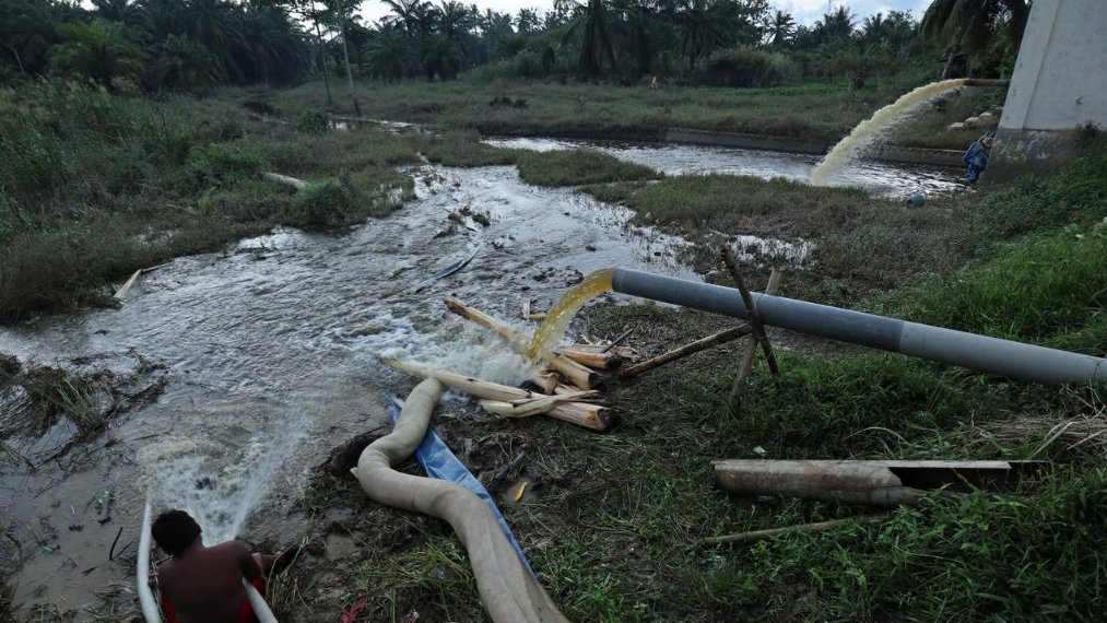 Pipa-pipa besar membuang air deras ke sungai dalam upaya penanganan banjir dan pompanisasi di lahan gambut atau area terdampak banjir. (Dok. BNPB)
