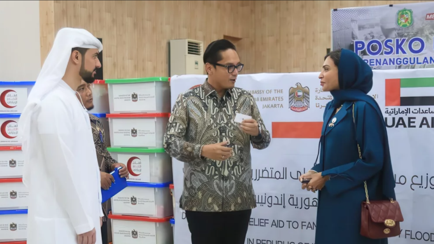 Wali Kota Medan, Rico Tri Putra Bayu Waas (tengah), berbincang dengan perwakilan pemerintah Uni Emirat Arab (UEA) saat prosesi pengembalian bantuan kemanusiaan di Medan, Kamis (18/12/2025). Tumpukan kotak bantuan terlihat di latar belakang. (Dok. Ist)