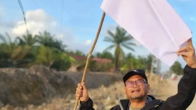 "Sudah 19 hari pascabencana, warga Aceh mengibarkan bendera putih tanda menyerah. Respons pemerintah pusat dinilai lamban, memicu ancaman aksi massa dan tuntutan status Bencana Nasional."