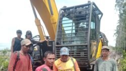 Sejumlah warga Desa Bika saat berada di dekat alat berat yang mereka tahan di lokasi perkebunan sebagai bentuk protes dalam konflik dengan PT Borneo International Anugerah (BIA).