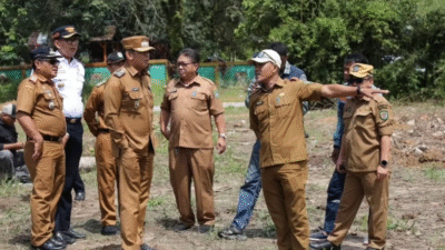 Wakil Wali Kota Singkawang dan rombongan pejabat menunjuk ke arah lahan kosong saat survei lokasi pembangunan sekolah di Singkawang Selatan. (Dok. HO/Faktakalbar.id)