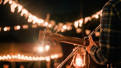 Ilustrasi musisi saat tampil membawakan lagu dengan iringan gitar di sebuah kafe.