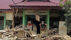 Sejumlah relawan dan guru membersihkan lumpur dan puing sisa banjir di Sekolah Luar Biasa (SLB) Negeri Pembina Aceh Tamiang, Selasa (13/1).