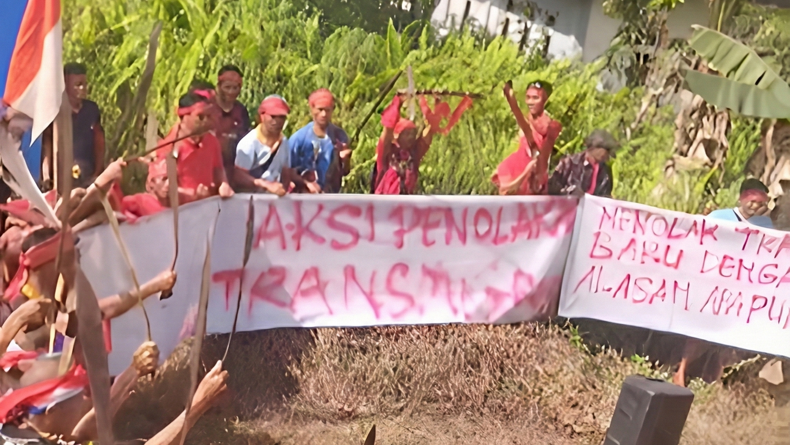 Warga Dusun Nibung, Kecamatan Seluas, membentangkan spanduk penolakan saat menggelar aksi damai menentang rencana kawasan transmigrasi di Kabupaten Bengkayang. (Dok: TikTok @darius.dan7)