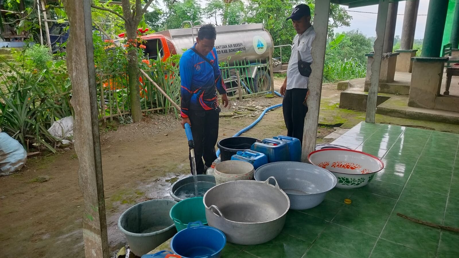 Petugas BPBD saat mendistribusikan air bersih kepada warga Desa Klekean, Kecamatan Botolinggo, untuk mengatasi dampak kekeringan di Kabupaten Bondowoso, Rabu (28/1/2026).