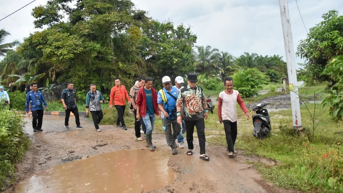Bupati Sujiwo didampingi jajaran perangkat daerah berjalan kaki meninjau kondisi jalan poros yang rusak dan berlubang di Desa Pinang Luar. (Dok. HO/Faktakalbar.id)