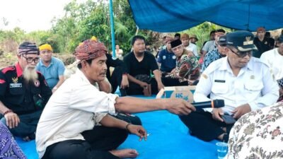 Camat Marau Supardi memberikan sambutan menggunakan mikrofon saat acara Pembukaan Adat pembangunan pabrik di Desa Sukakarya, Ketapang. (Dok. HO/Faktakalbar.id)