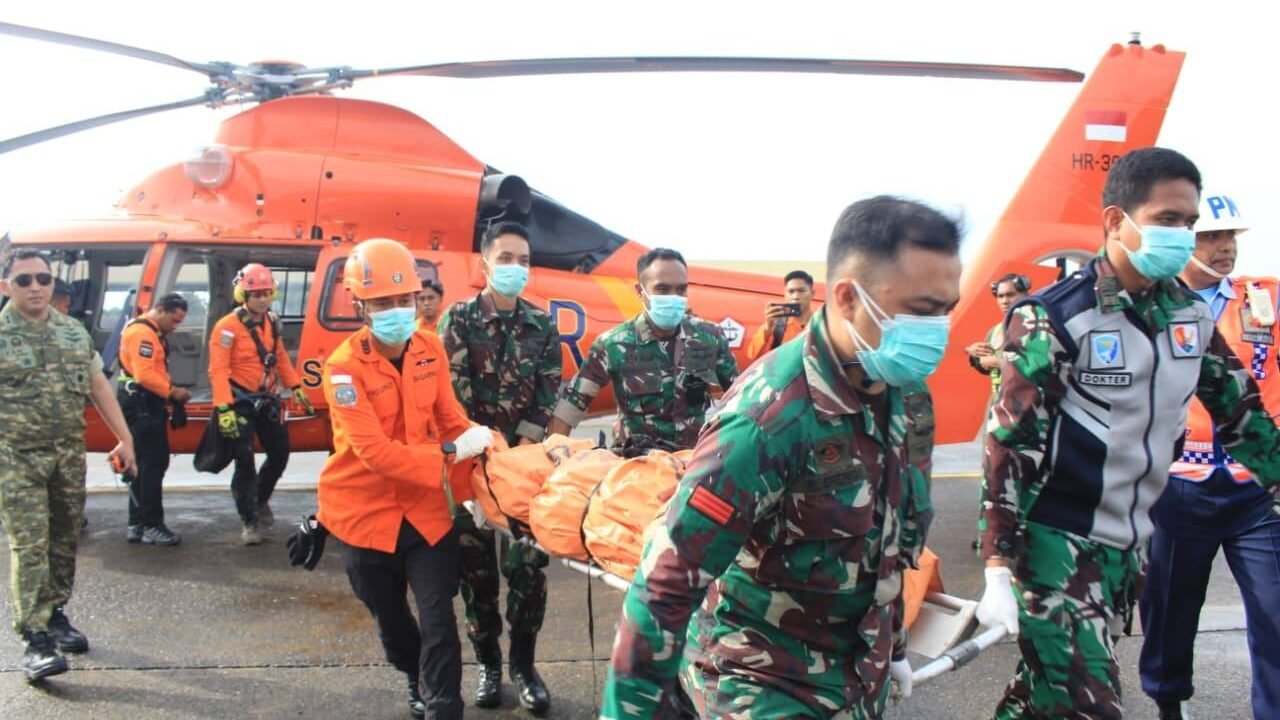 Personel Tim SAR Gabungan dan TNI AU menandu kantong jenazah korban pesawat jatuh dari helikopter Basarnas di Lanud Sultan Hasanuddin. (Dok. HO/Faktakalbar.id)