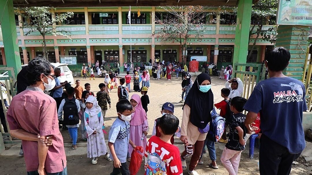 Suasana keramaian orang tua dan siswa di gerbang SDN 1 Karang Baru, Aceh Tamiang, pada hari pertama masuk sekolah pascabanjir dengan latar belakang gedung sekolah bertingkat dua. (Dok. HO/Faktakalbar.id)