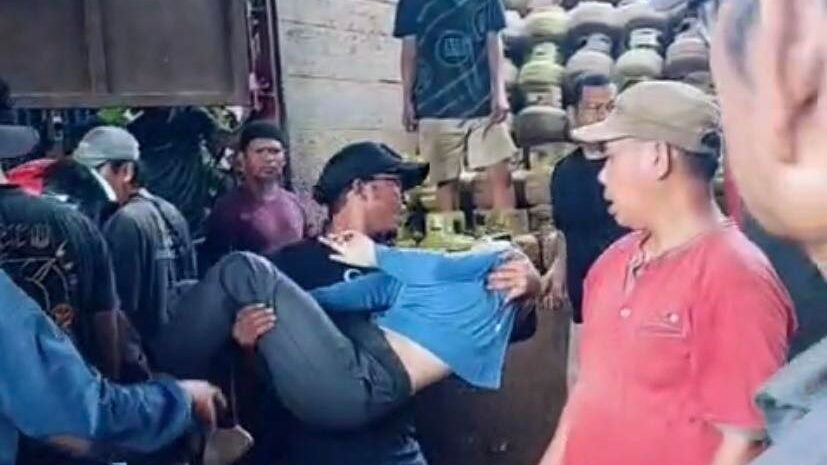 Warga mengevakuasi seorang ibu rumah tangga yang pingsan saat mengantre gas LPG di salah satu pangkalan di wilayah Putussibau Selatan, Kapuas Hulu, Selasa (30/12/2025). (Dok. ISt)