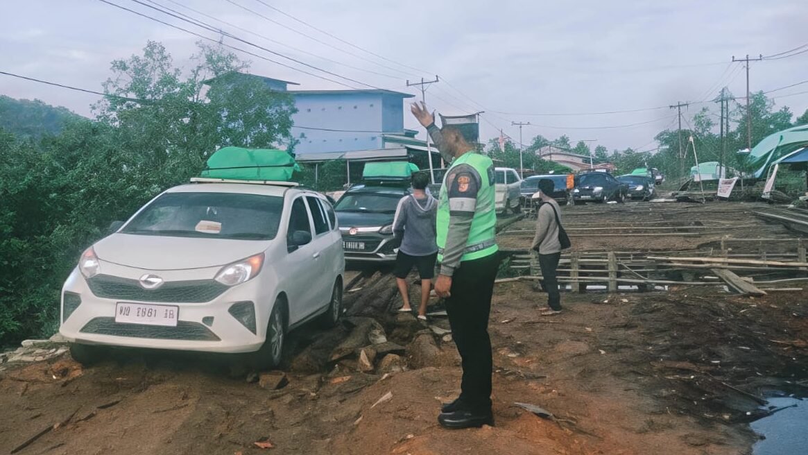 "Jembatan Gunung Lalang di Kayong Utara alami kerusakan serius. Struktur hanya berupa susunan kayu dan jalan tanah berlumpur, akses warga terhambat."