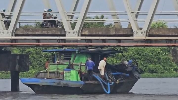 Sebuah kapal motor terjebak di bawah kolong Jembatan Pawan 1, Kabupaten Ketapang, akibat naiknya permukaan air sungai saat fenomena pasang rob, Senin (5/1/2026). (Dok. Ist)