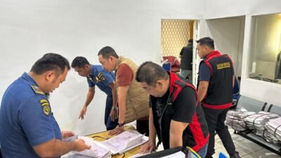 Sejumlah penyidik Kejati Kalbar mengenakan rompi khusus satuan pemberantasan korupsi sedang memeriksa tumpukan berkas dan dokumen di atas meja saat penggeledahan di ruangan kantor KSOP Ketapang. (Dok. HO/Faktakalbar.id)