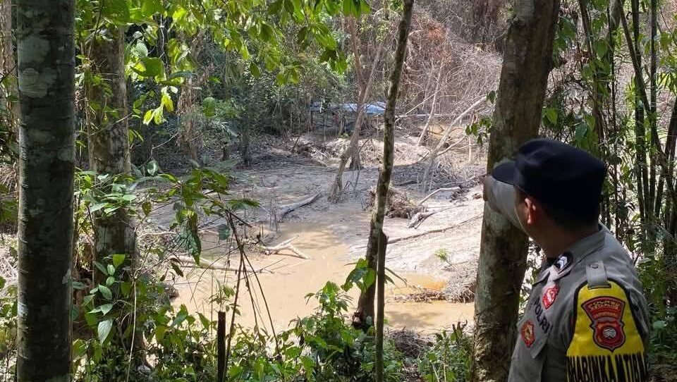 Personel Polsek Jelai Hulu saat melakukan pengecekan langsung kondisi air sungai yang keruh akibat dugaan aktivitas pertambangan ilegal.