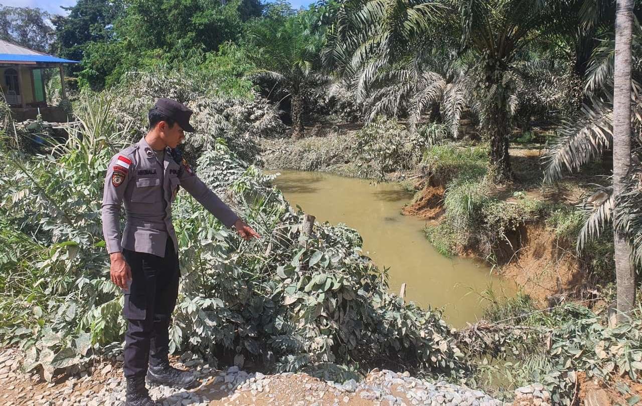 Petugas kepolisian melakukan pengecekan debit air Sungai dan kondisi infrastruktur jembatan pasca banjir di Kecamatan Entikong, Sabtu (10/1).