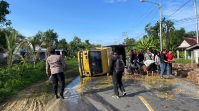 Sejumlah warga dan petugas kepolisian bahu-membahu membantu mengevakuasi muatan dari truk pengangkut telur yang terguling di Desa Tanjung Keracut, Kecamatan Teluk Keramat.