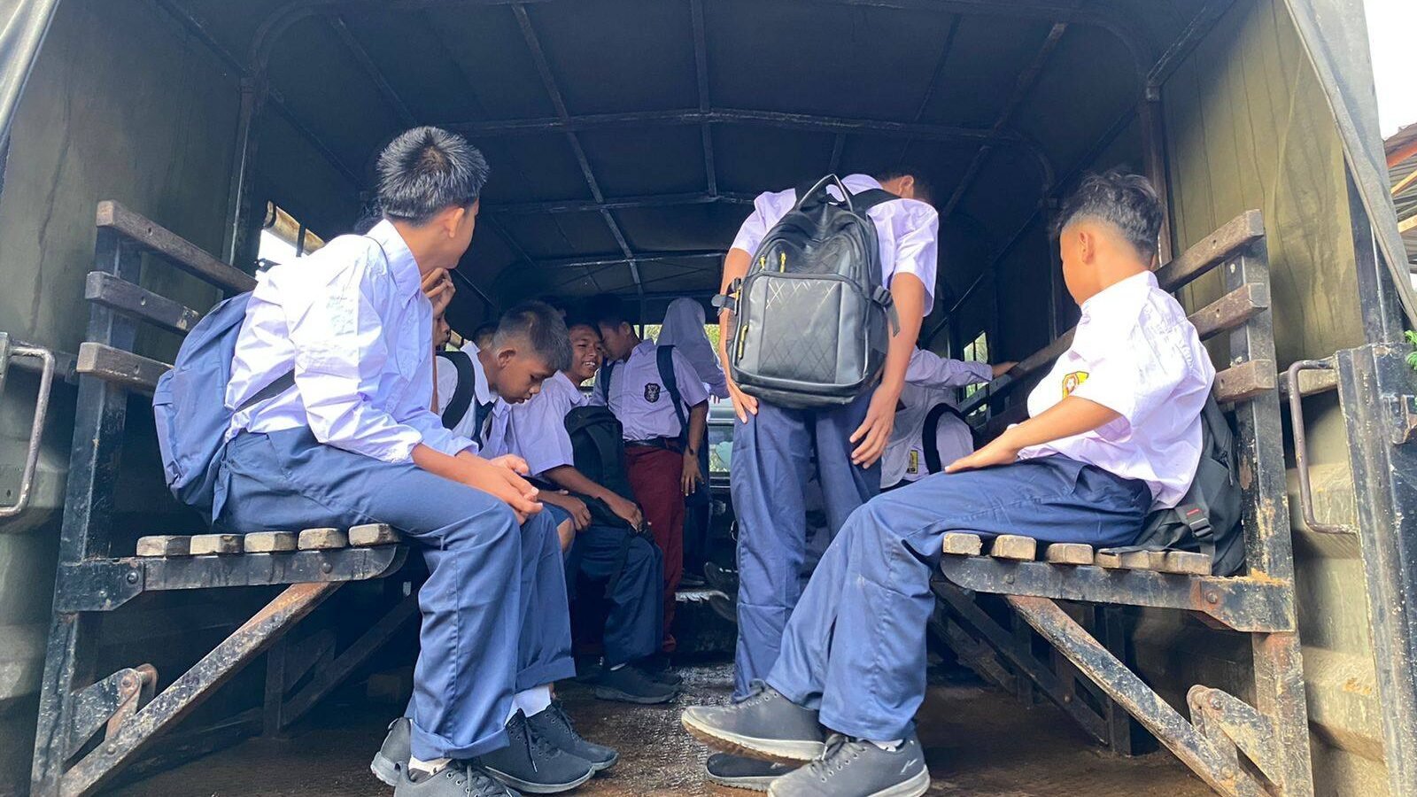 Sejumlah siswa berseragam sekolah dasar dan menengah duduk di dalam truk dinas Marinir TNI AL yang mengantar mereka ke sekolah pasca banjir di Batang Toru. (Dok. HO/Faktakalbar.id)