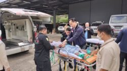 Petugas KJRI Kuching bersama tim medis memindahkan Samsul Qhahar, WNI asal Sambas yang sakit, dari ambulans di PLBN Aruk. (Dok. HO/Faktakalbar.id)