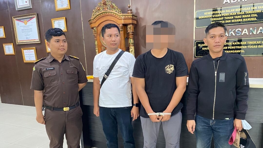 Tim Jaksa Eksekutor Kejaksaan Negeri Pontianak mengapit terpidana kasus perbankan berinisial OH yang mengenakan baju hitam dengan tangan terborgol usai penangkapan. (Dok. HO/Faktakalbar.id)