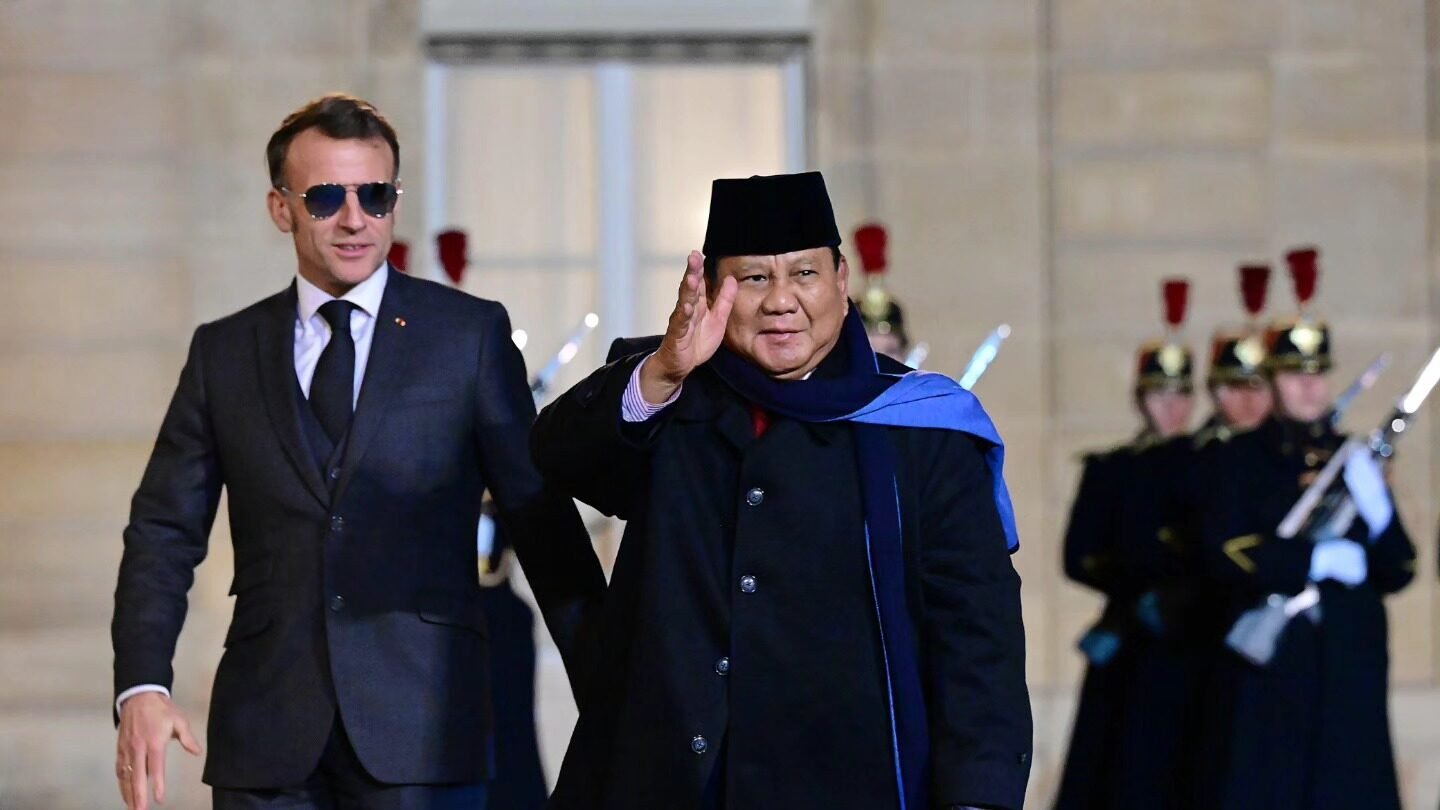Presiden Prabowo Subianto mengenakan mantel hitam dan peci melambaikan tangan saat disambut oleh Presiden Emmanuel Macron di Paris. (Dok. HO/Faktakalbar.id)