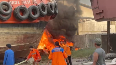 Petugas pemadam kebakaran saat melakukan upaya pemadaman dan pendinginan di lokasi kebakaran kawasan PT Rimba Mega Armada, Jalan Tanjung Hilir, Kamis (22/1).