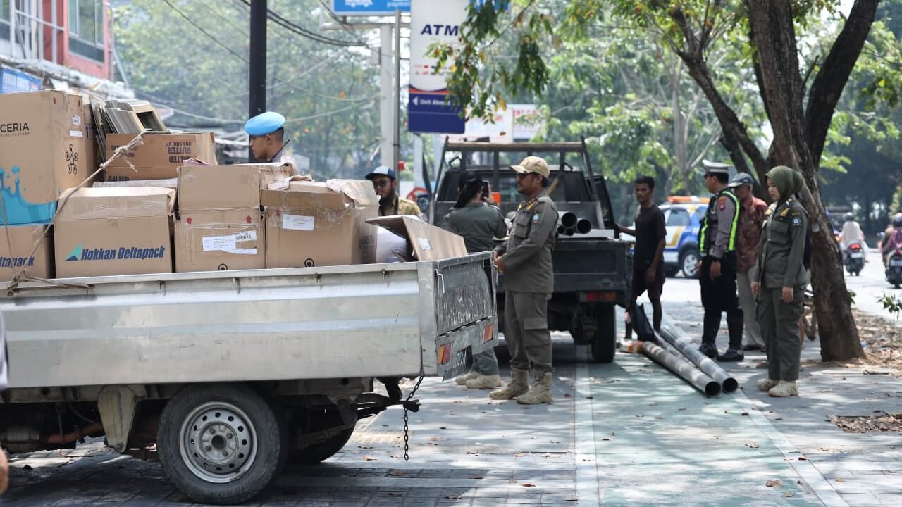 Petugas gabungan dari Dishub, Satpol PP, TNI, dan Polri saat melakukan penertiban kendaraan yang parkir di area terlarang di salah satu ruas jalan Kota Pontianak, Selasa (27/1).