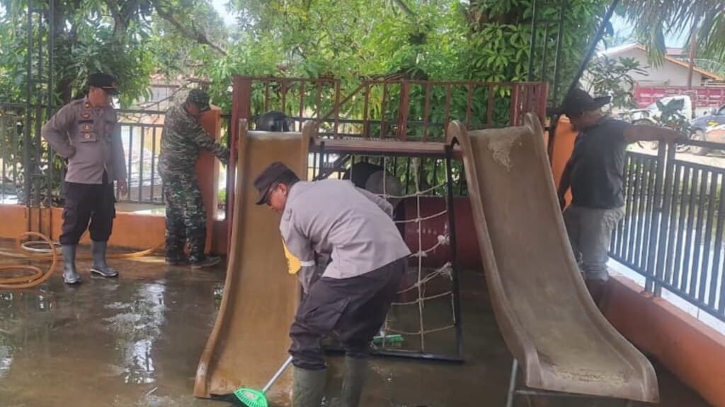 Personel gabungan dari TNI, Polri, BPBD, dan instansi terkait saat bahu-membahu membersihkan sisa lumpur di fasilitas umum di Sekadau Hulu, Sabtu (10/1).
