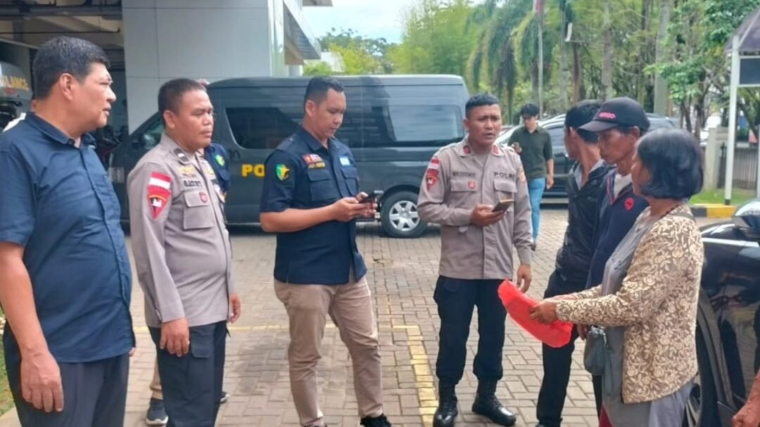 Anggota kepolisian berseragam dinas sedang berbicara dengan keluarga korban dan menyerahkan dokumen atau barang milik almarhumah di area parkir Rumah Sakit Bhayangkara Pontianak. (Dok. HO/Faktakalbar.id)