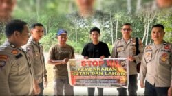 Personel Satbinmas Polres Sekadau bersama warga membentangkan spanduk imbauan stop pembakaran hutan dan lahan di Desa Mungguk. (Dok. HO/Faktakalbar.id)