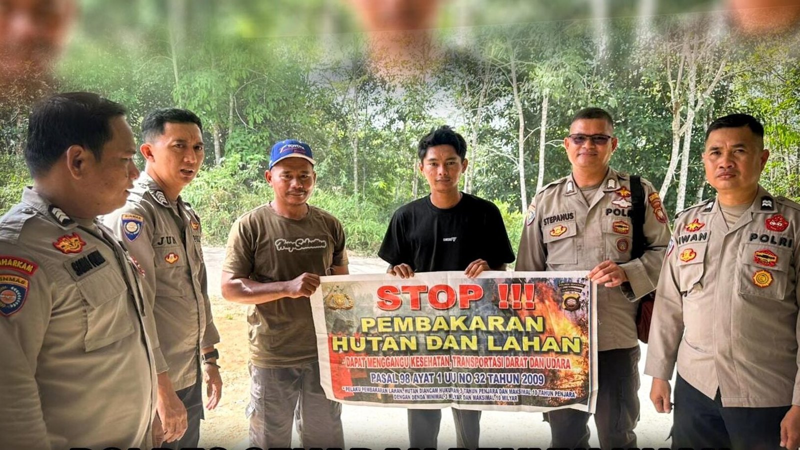 Personel Satbinmas Polres Sekadau bersama warga membentangkan spanduk imbauan stop pembakaran hutan dan lahan di Desa Mungguk. (Dok. HO/Faktakalbar.id)