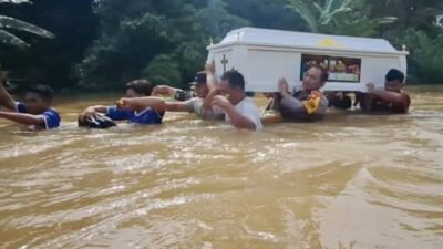 Lewati 3 Titik Banjir, Polisi dan Warga Panggul Peti Jenazah Tujuan Kayan di Tengah Arus Deras