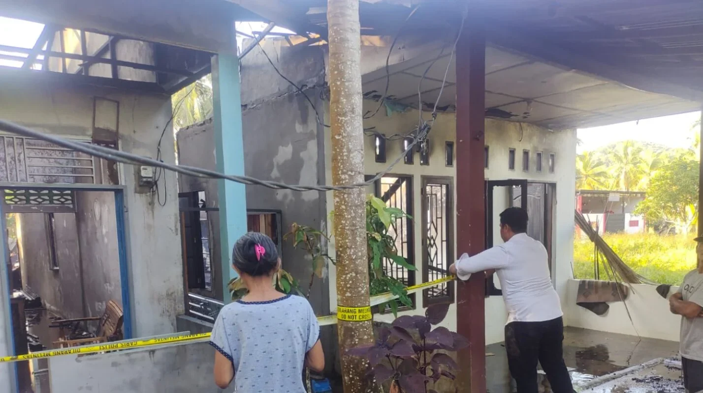 Petugas kepolisian dan pemadam kebakaran saat melakukan pendinginan dan pemeriksaan di lokasi kebakaran dua rumah warga di Desa Sungai Purun Kecil, Senin (12/1).