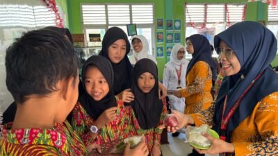 Petugas dari RSUD SSMA Pontianak berinteraksi dan membagikan buah kepada siswa SDN 74 Pontianak Barat dalam kegiatan edukasi gizi seimbang. (Dok. HO/Faktakalbar.id)
