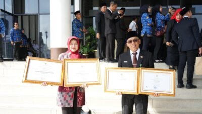 Sekretaris Daerah Kota Pontianak, Amirullah, bersama Kepala Dinas Perpustakaan dan Kearsipan, Rendrayani, memperlihatkan dua piagam penghargaan yang diraih pada HUT ke-69 Pemprov Kalbar. (Dok. HO/Faktakalbar.id)