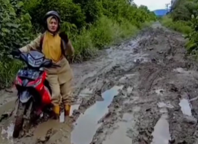 Seorang guru SDN 18 Sui Dungun di Kabupaten Sambas harus berjuang melewati jalanan berlumpur yang rusak parah untuk menuju sekolah tempatnya mengajar.