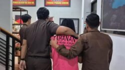 Luluk Hariadi saat digiring petugas Kejaksaan Negeri Bondowoso menuju mobil tahanan setelah resmi ditetapkan sebagai tersangka kasus dugaan korupsi dana hibah seragam tahun 2024, Senin (26/1/2026).